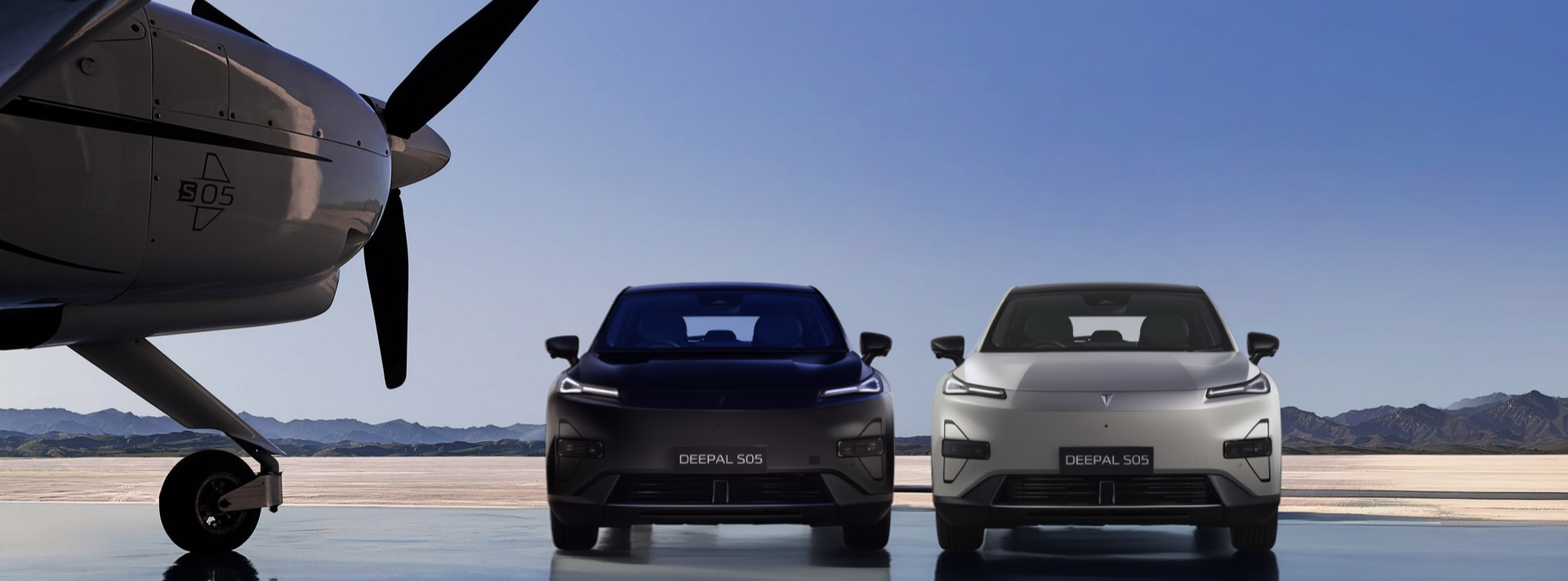 Dos SUV eléctricos Changan Deepal S05, uno negro y otro blanco, en una pista junto a una avioneta
